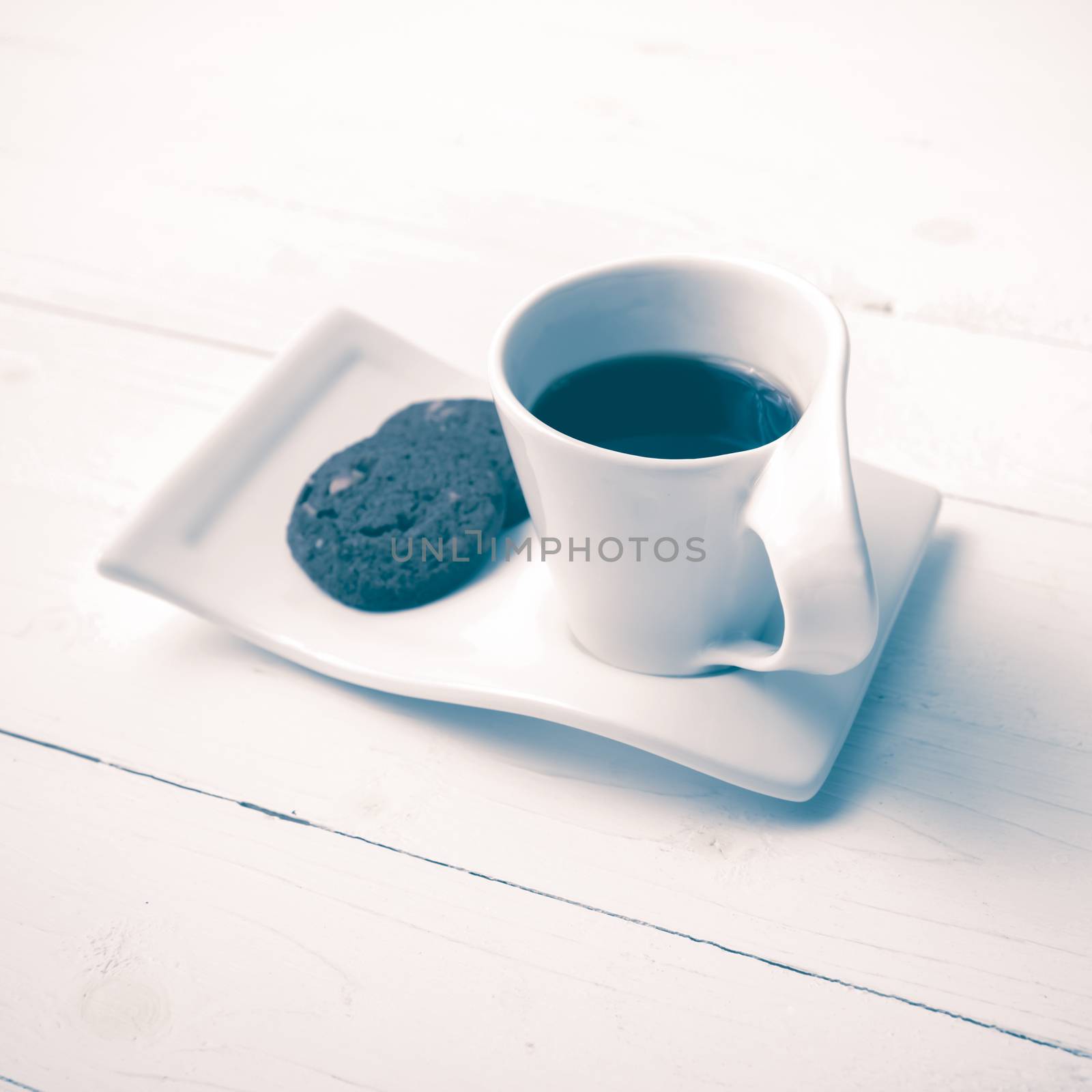 coffee cup with cookie on white wood background vintage style