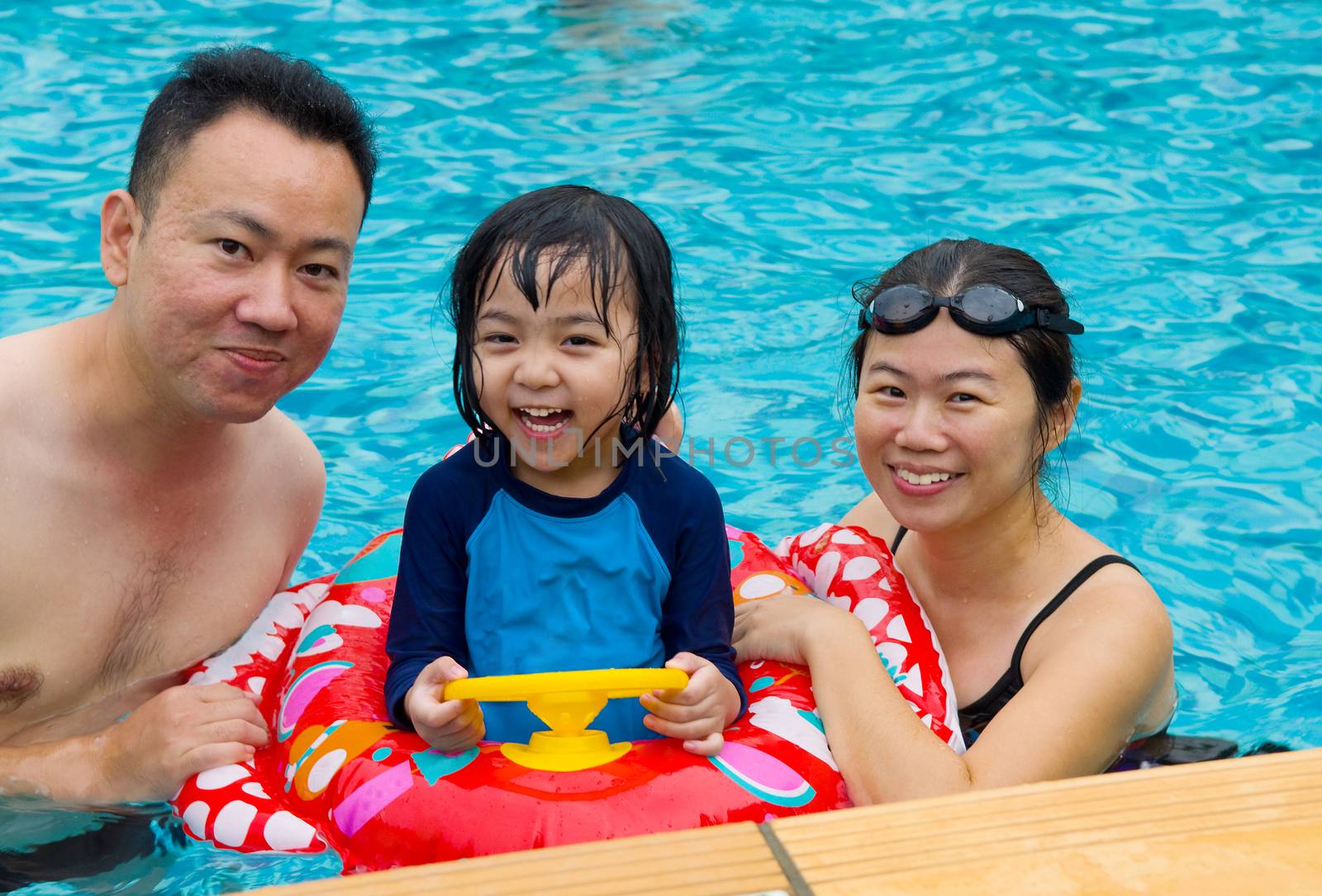 happy family playing in the pool
