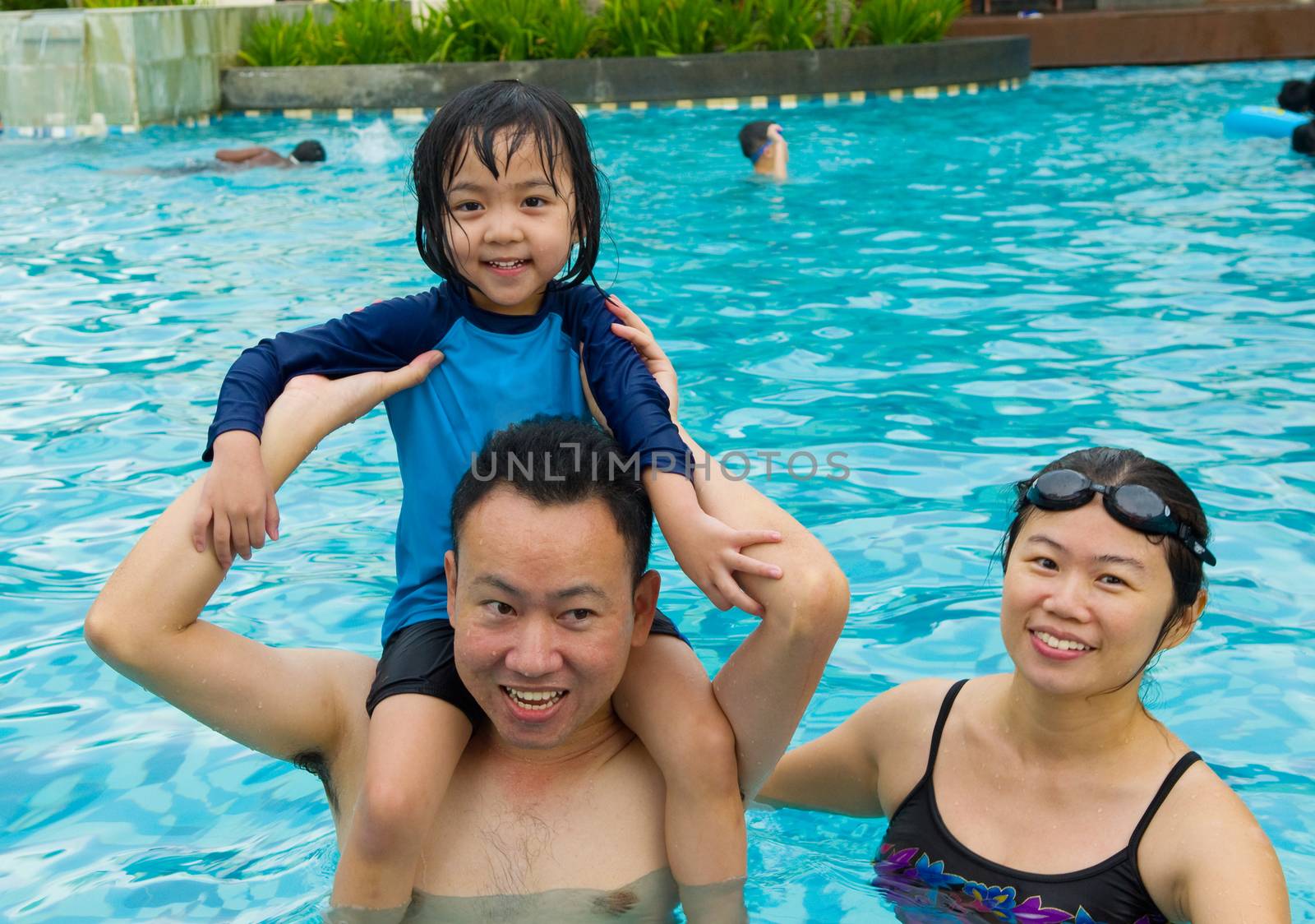 happy family playing in the pool