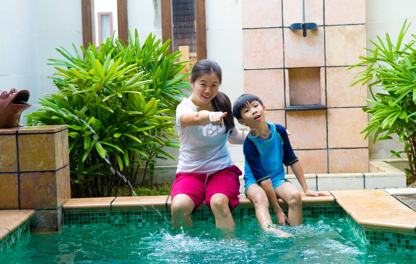Happy chinese Asian Family Playing in the pool