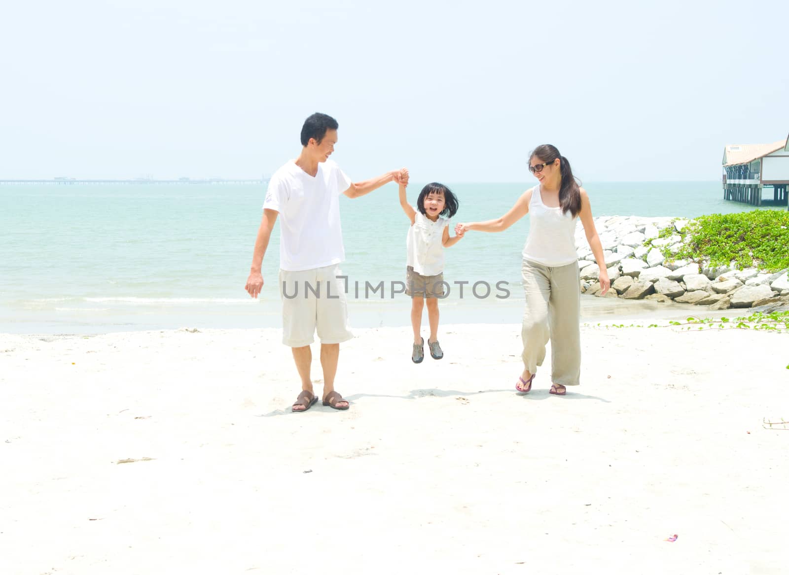 Happy family having fun at beach during summer day