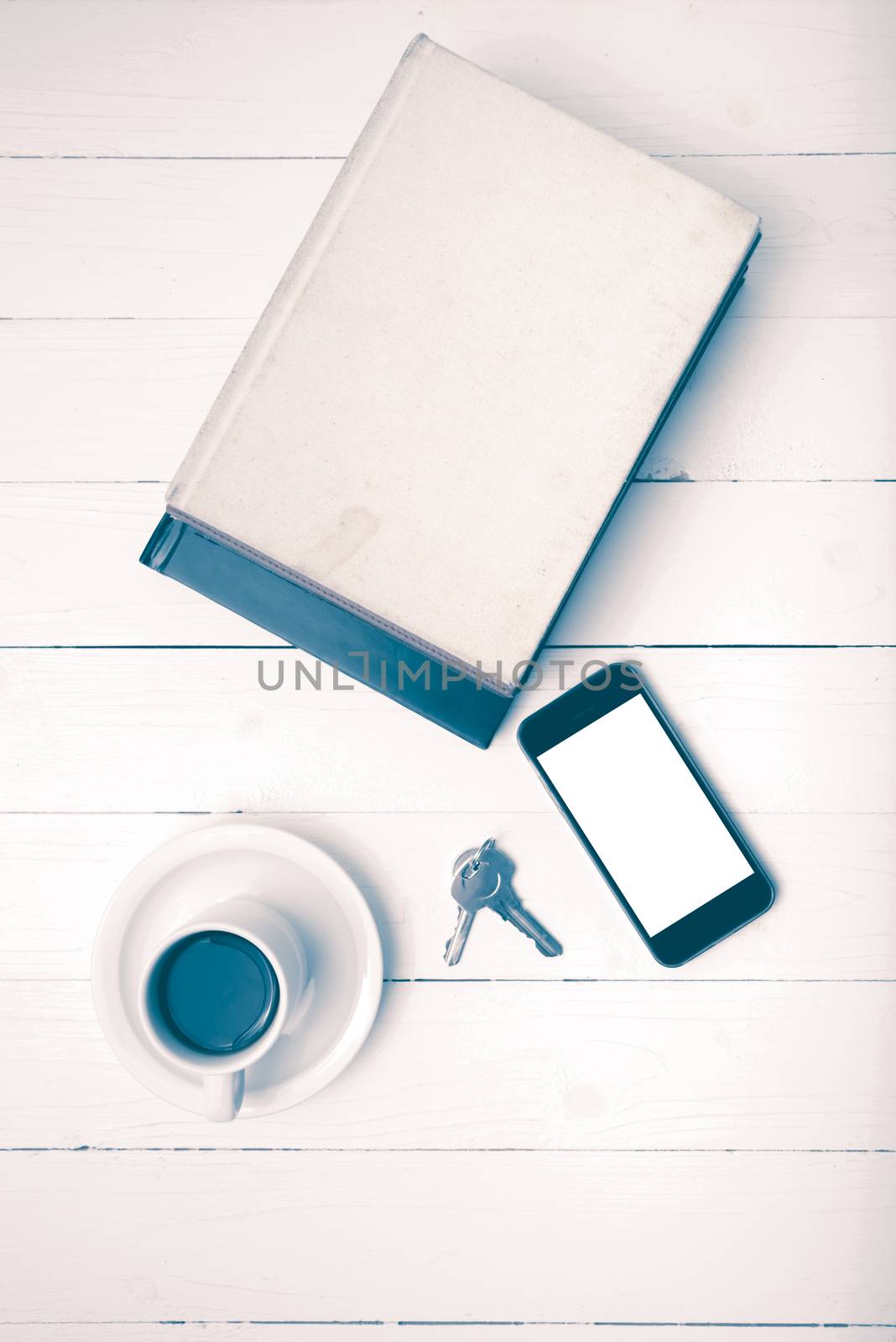 coffee cup with phone,key and stack of book on white wood table vintage style