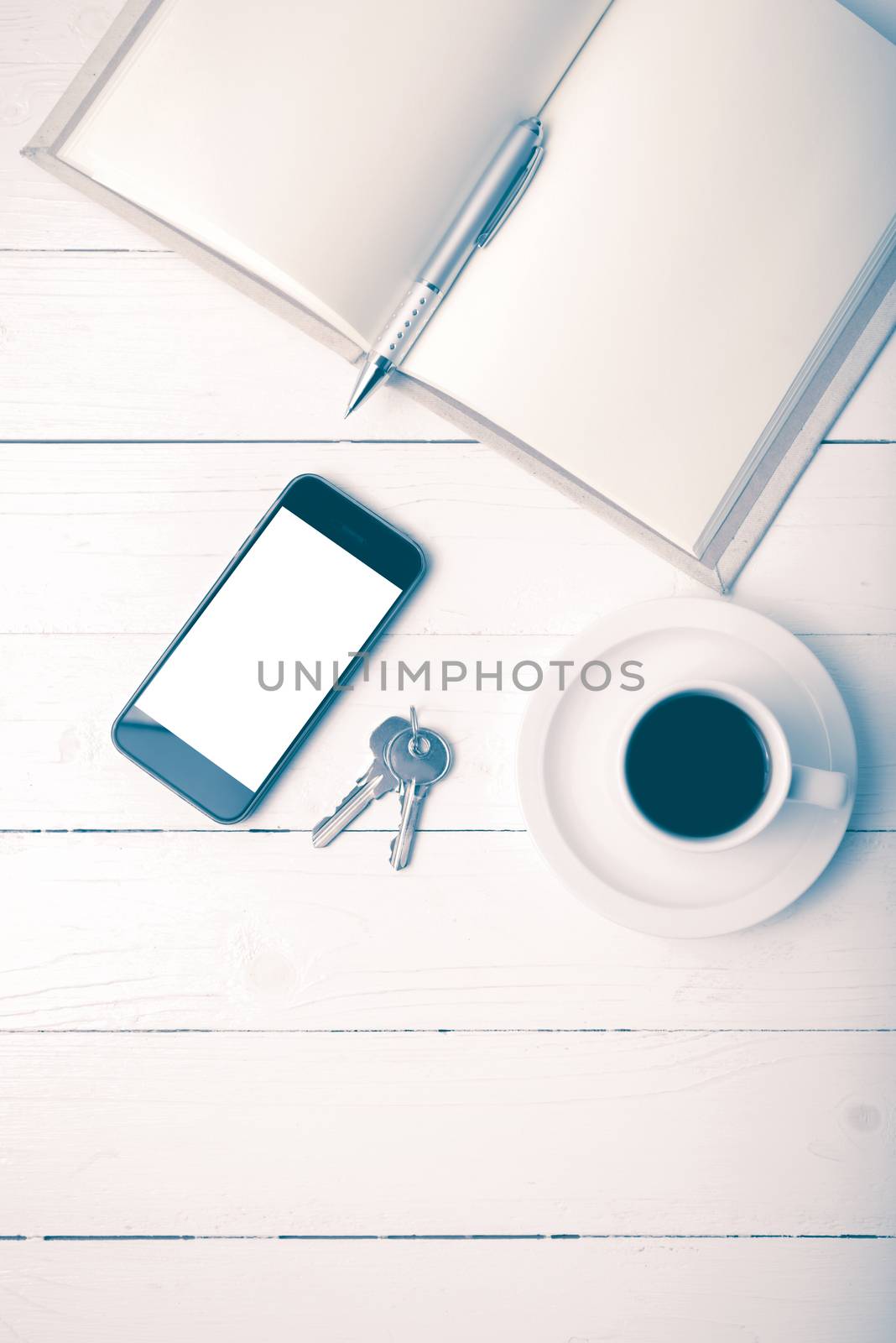 coffee cup with phone, key and open notebook on white wood table vintage style