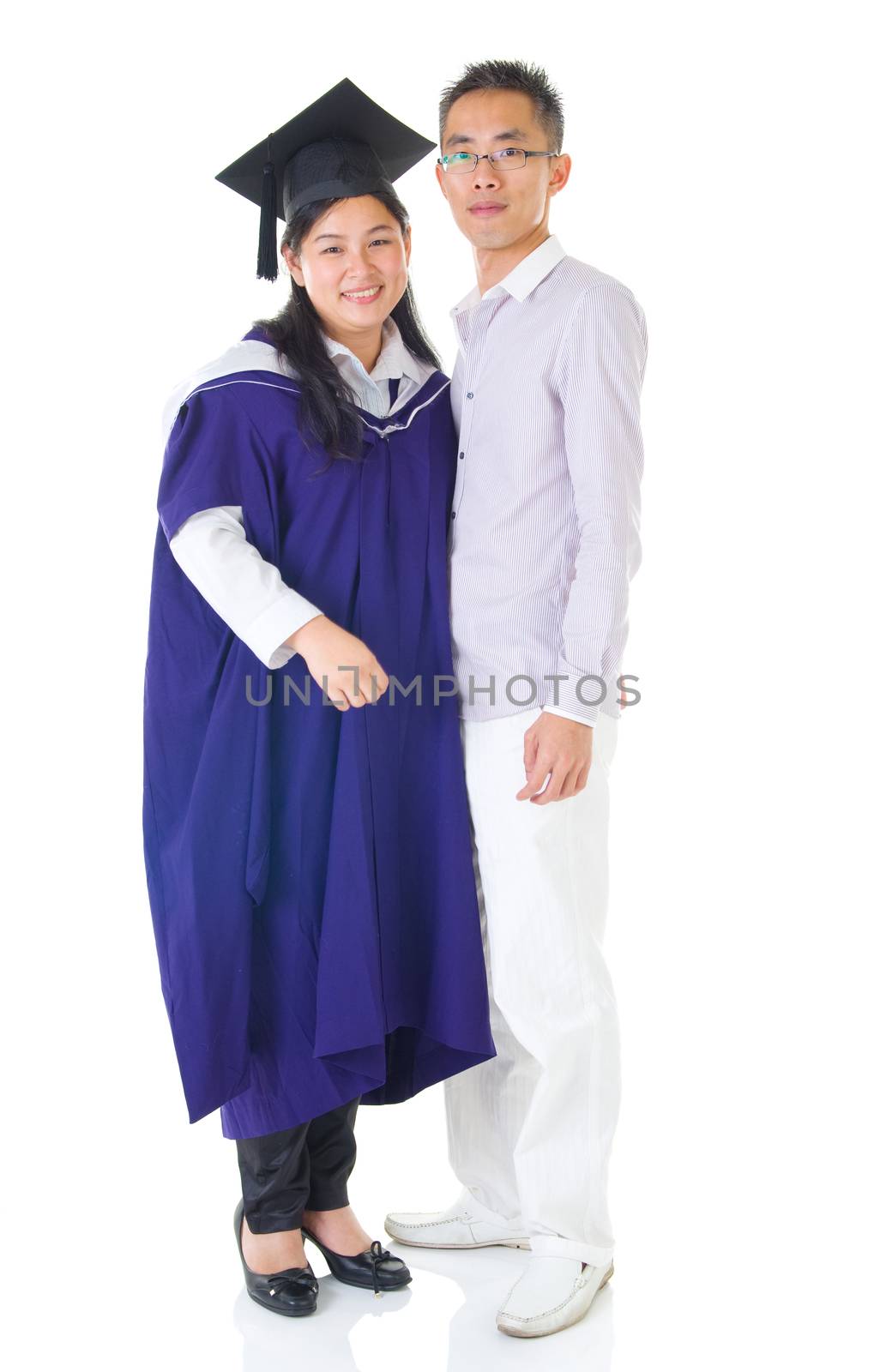 Asian woman in graduation gown.Taking photo with her husband.