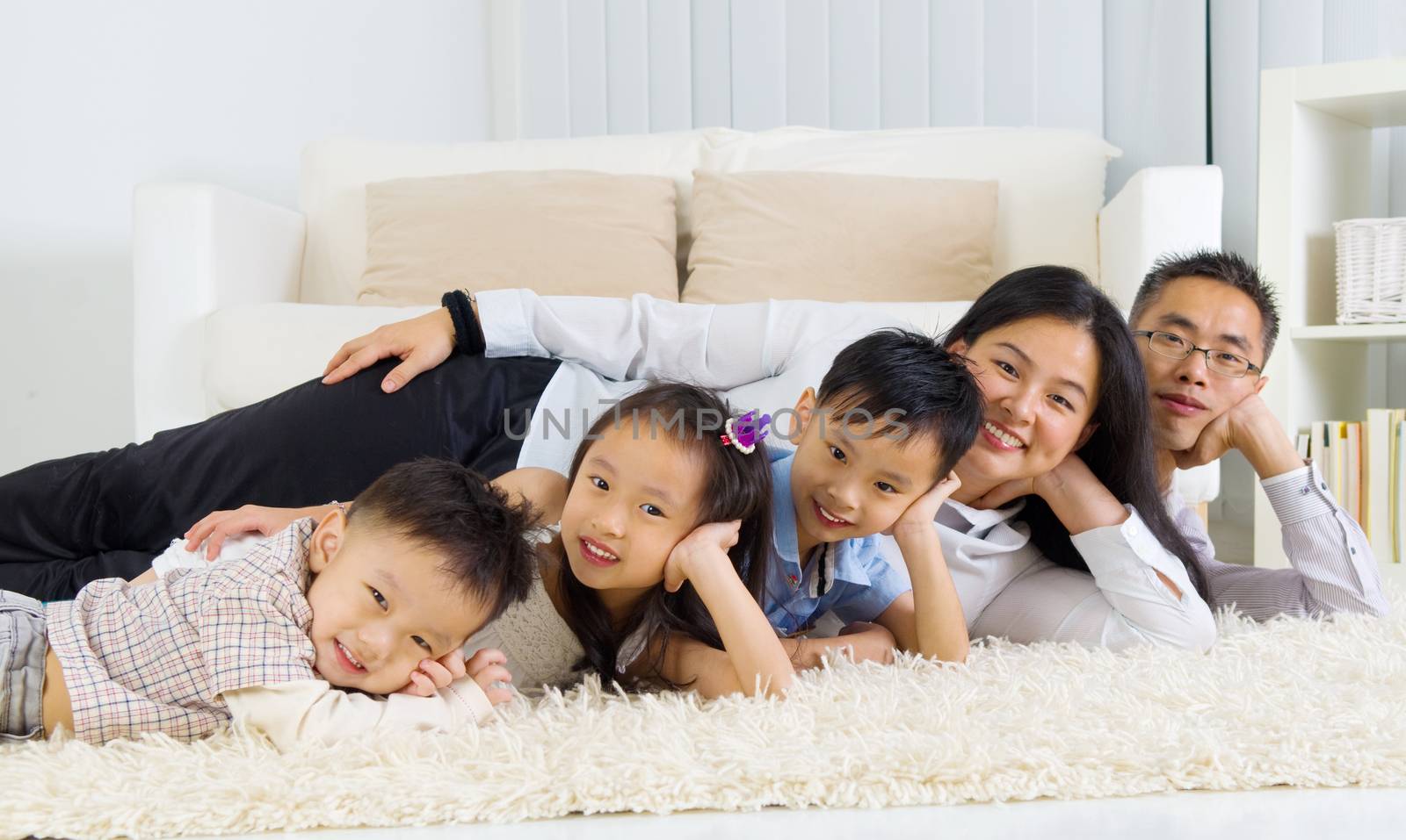 Asian family lying on the floor and smiling