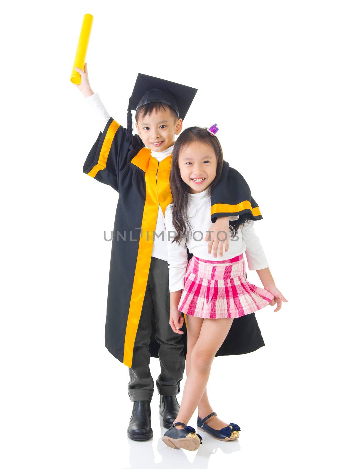 Asian school kid graduate in graduation gown and cap. Taking photo with sister and brother.