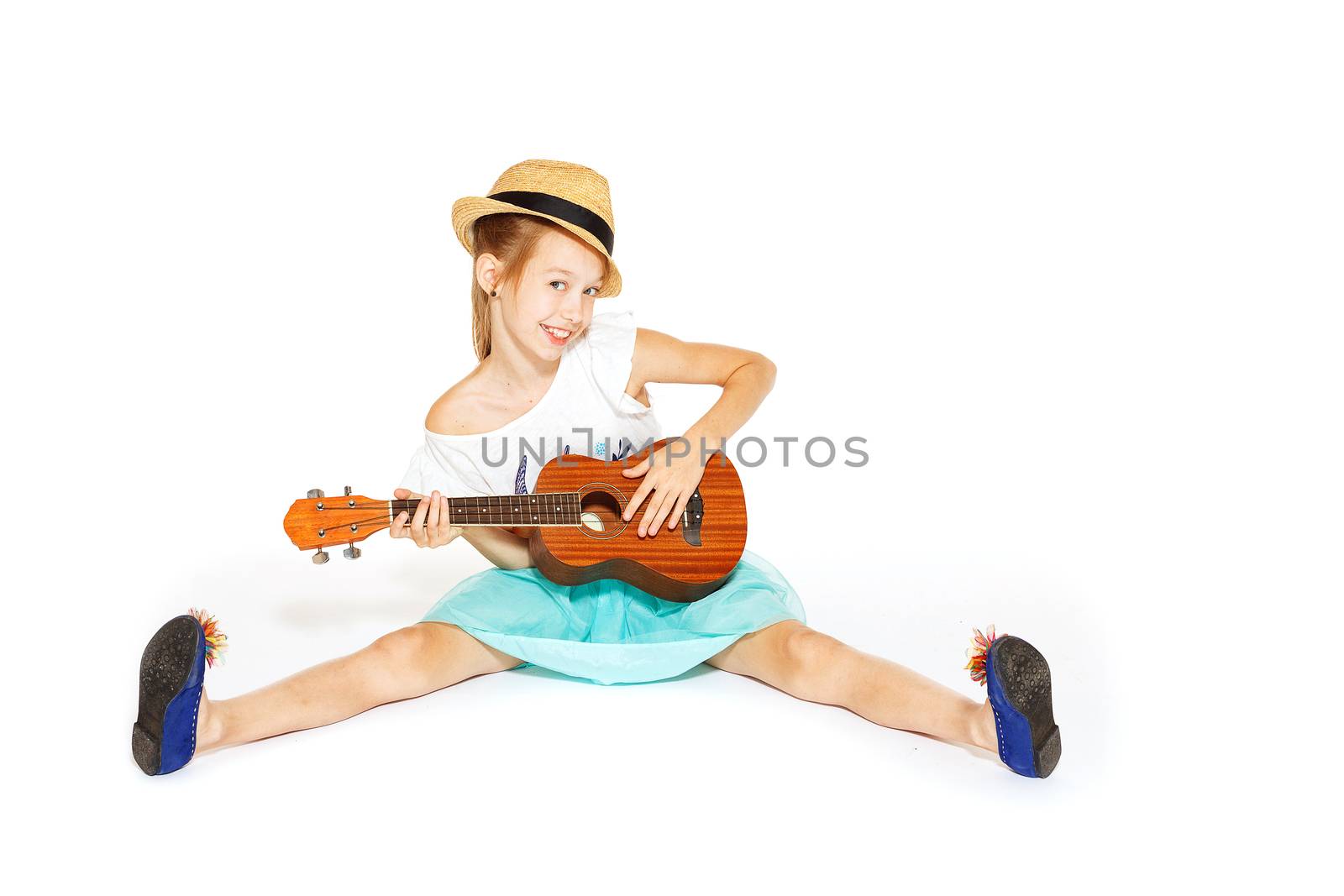 A beautiful little girl with a charming smile with a guitar