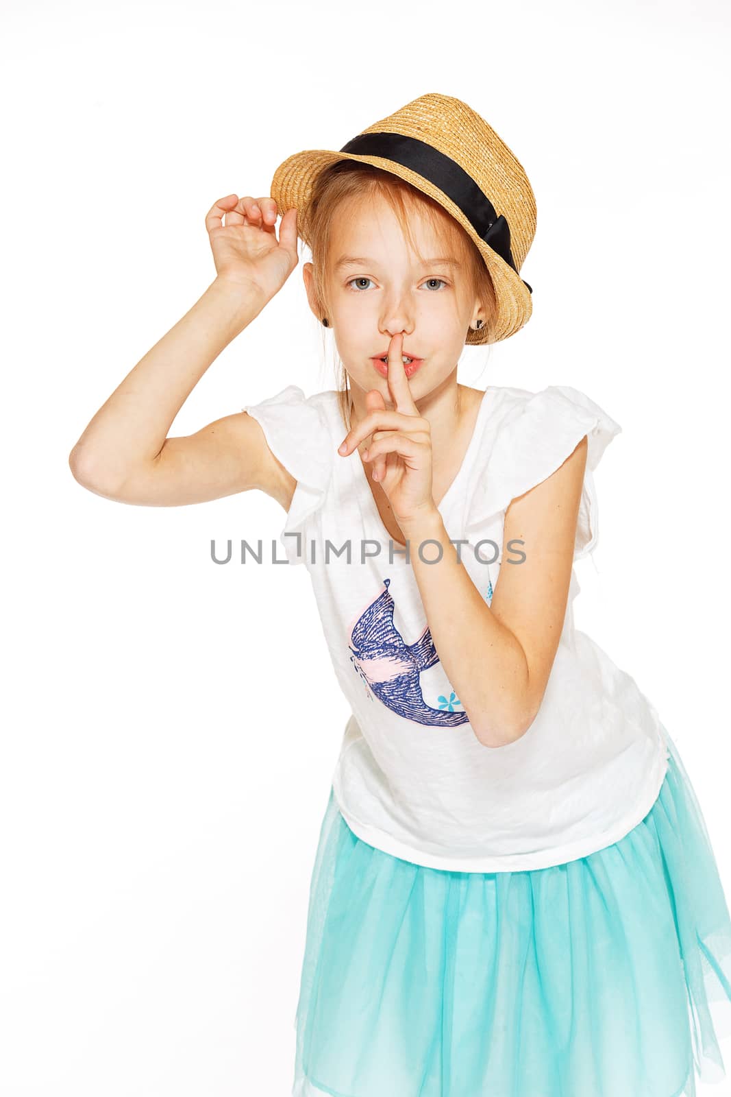 Little girl posing for the camera in a brown hat