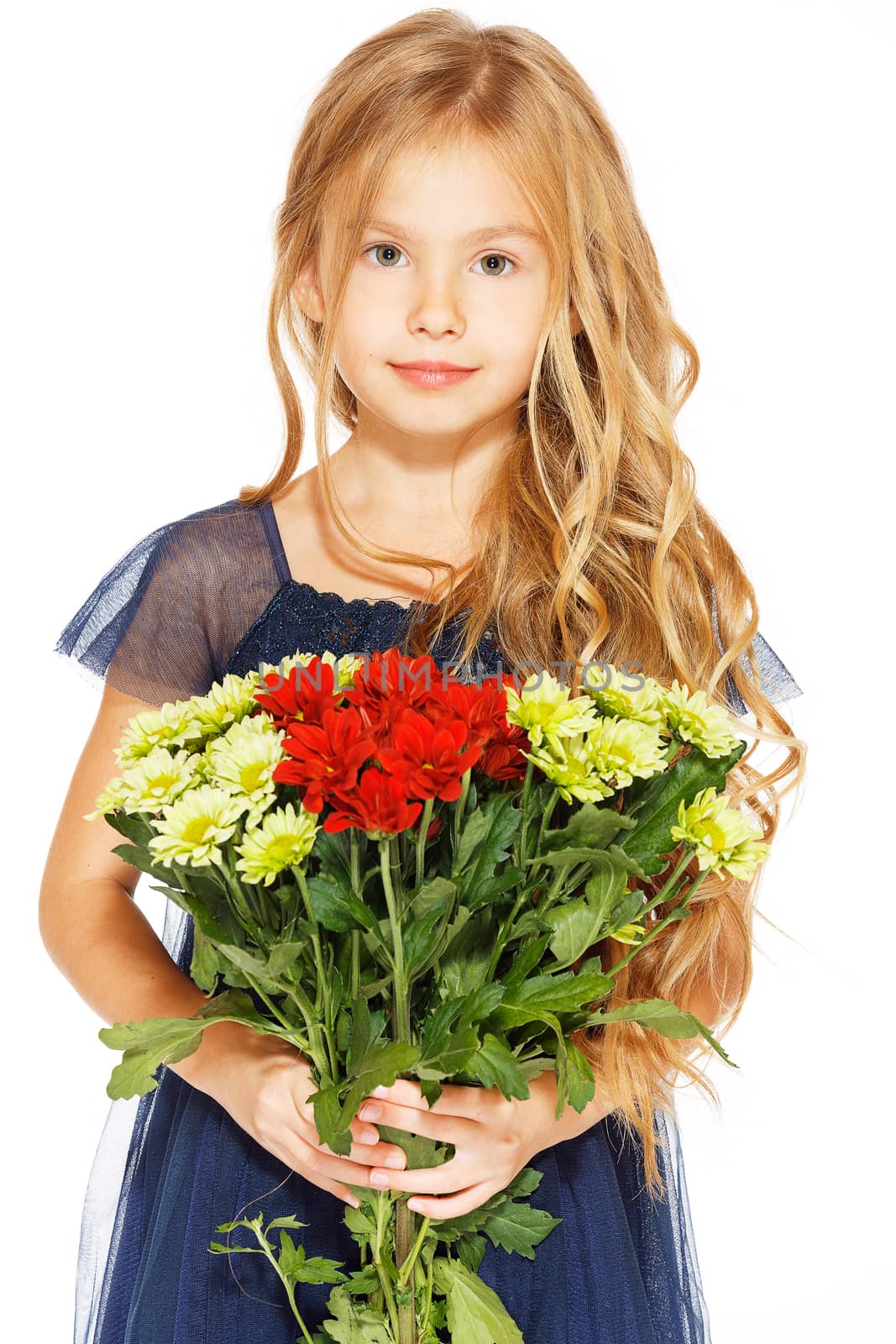 Charming little girl with curly hair in a blue dress with a bouquet of flowers