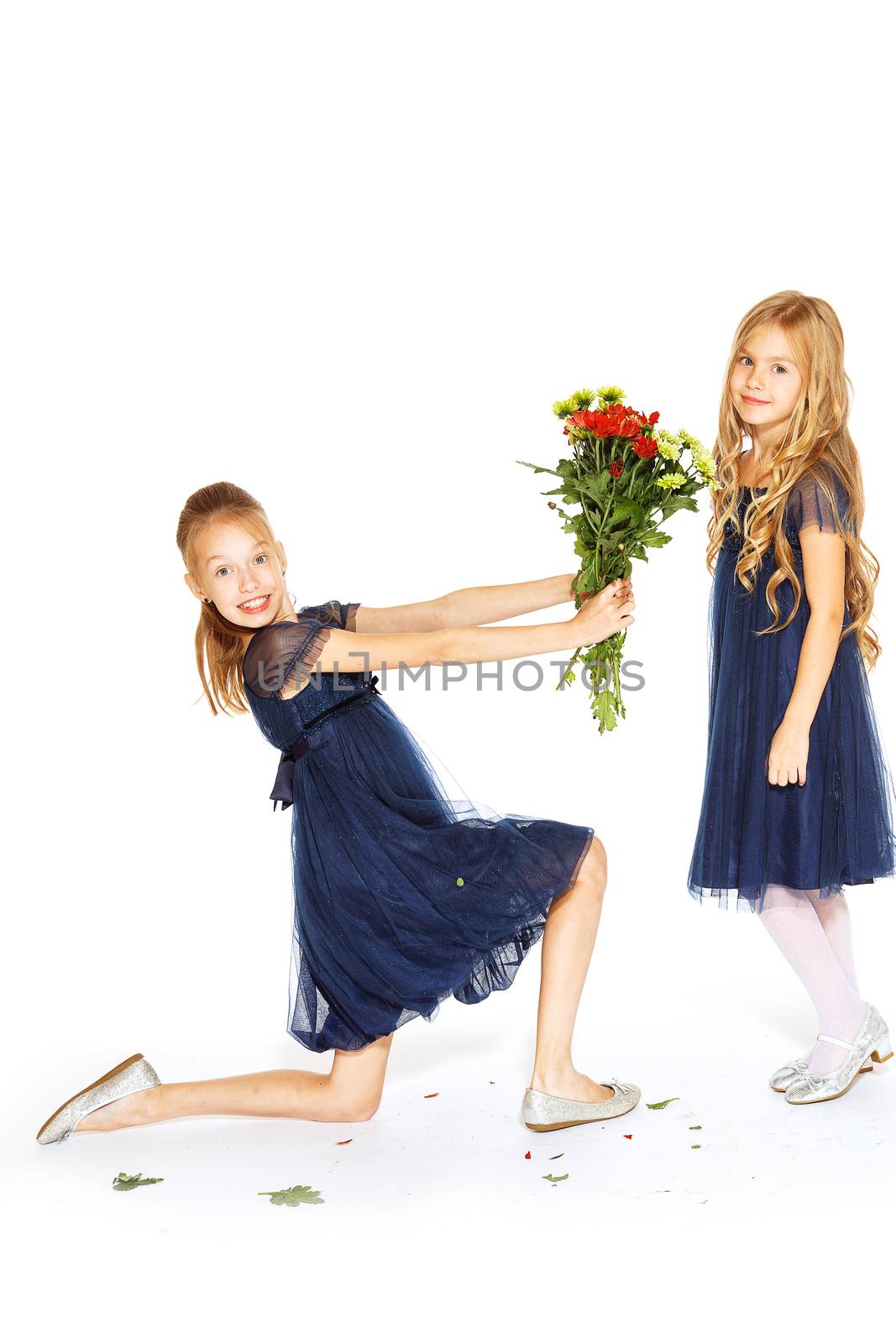 Two charming little girls in a blue dresses with a bouquet of flowers