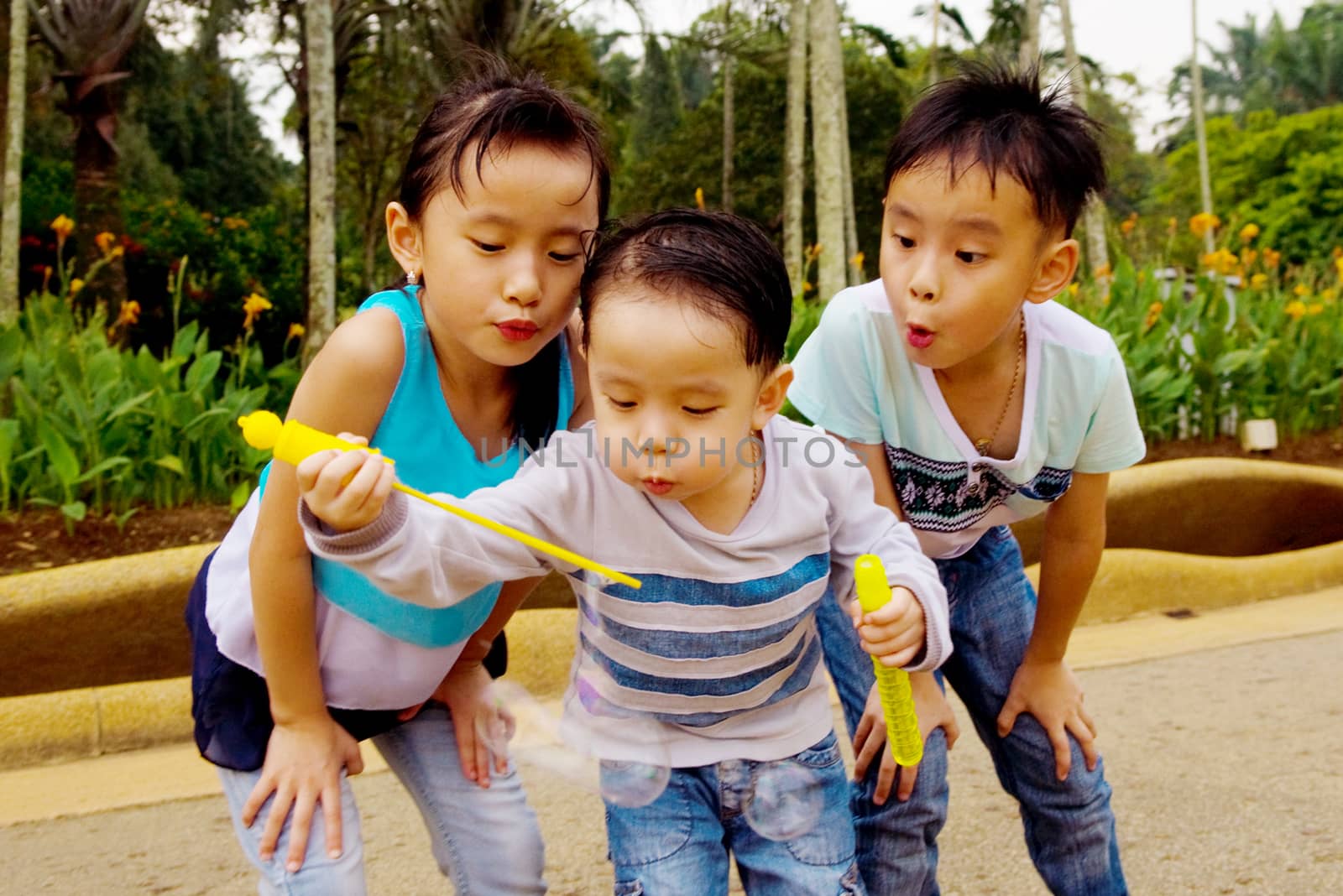 Asian kids blowing bubbles outdoor