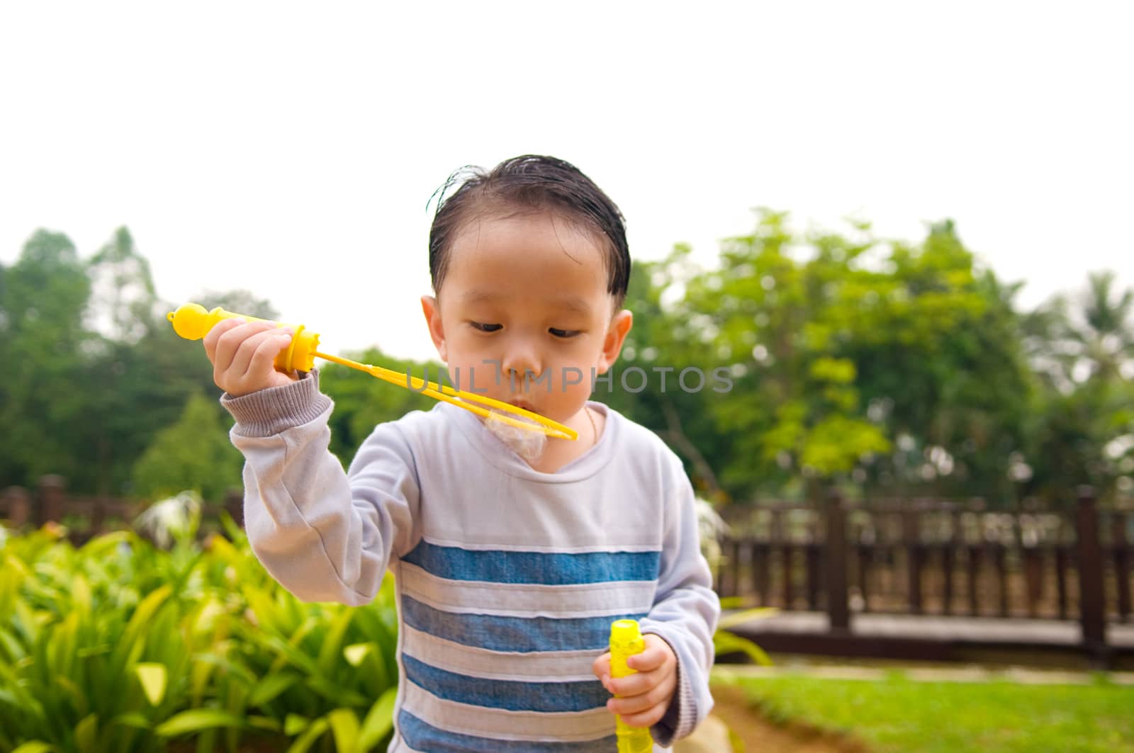 Asian boy blowing bubbles outdoor