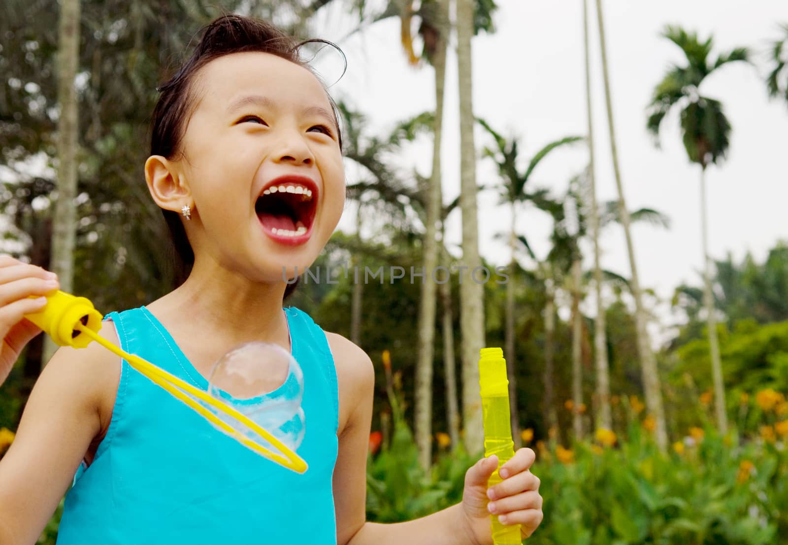 Asian girl blowing bubbles outdoor