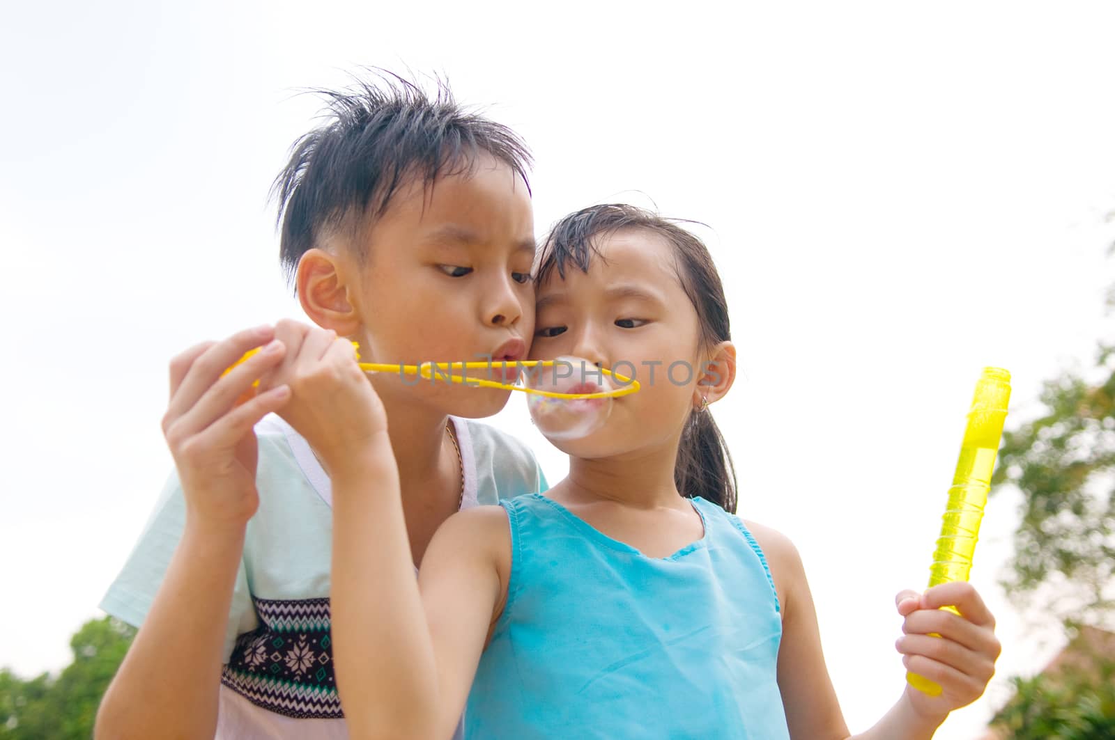 Asian kids blowing bubbles outdoor