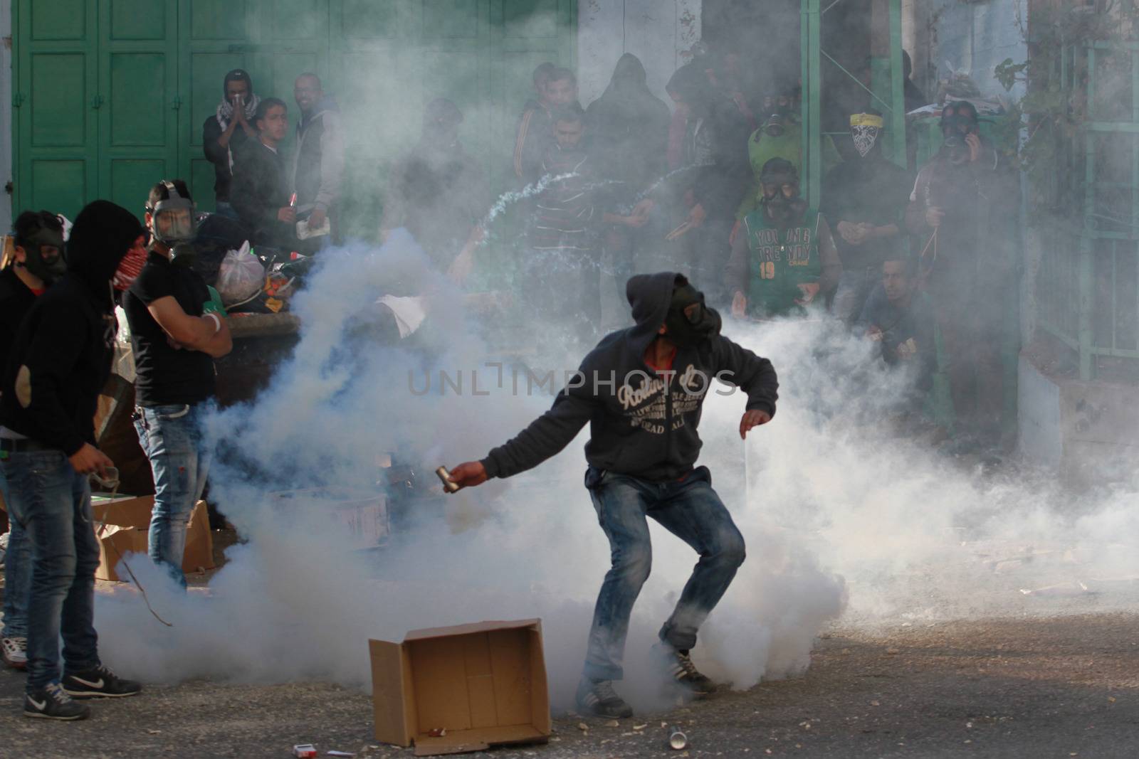 WEST BANK, Bethlehem: A Palestinian protester throws back a tear gas can towards Israeli security forces during clashes in the West Bank town of Bethlehem following a funeral ceremony at the nearby Aida refugee camp on January 13, 2016. A Palestinian man identified as Srur Ahmad Abu Srur, 21, was buried at Aida refugee camp a day after he was allegedly shot in the chest by Israeli forces in Beit Jala, a Palestinian health ministry statement said. 