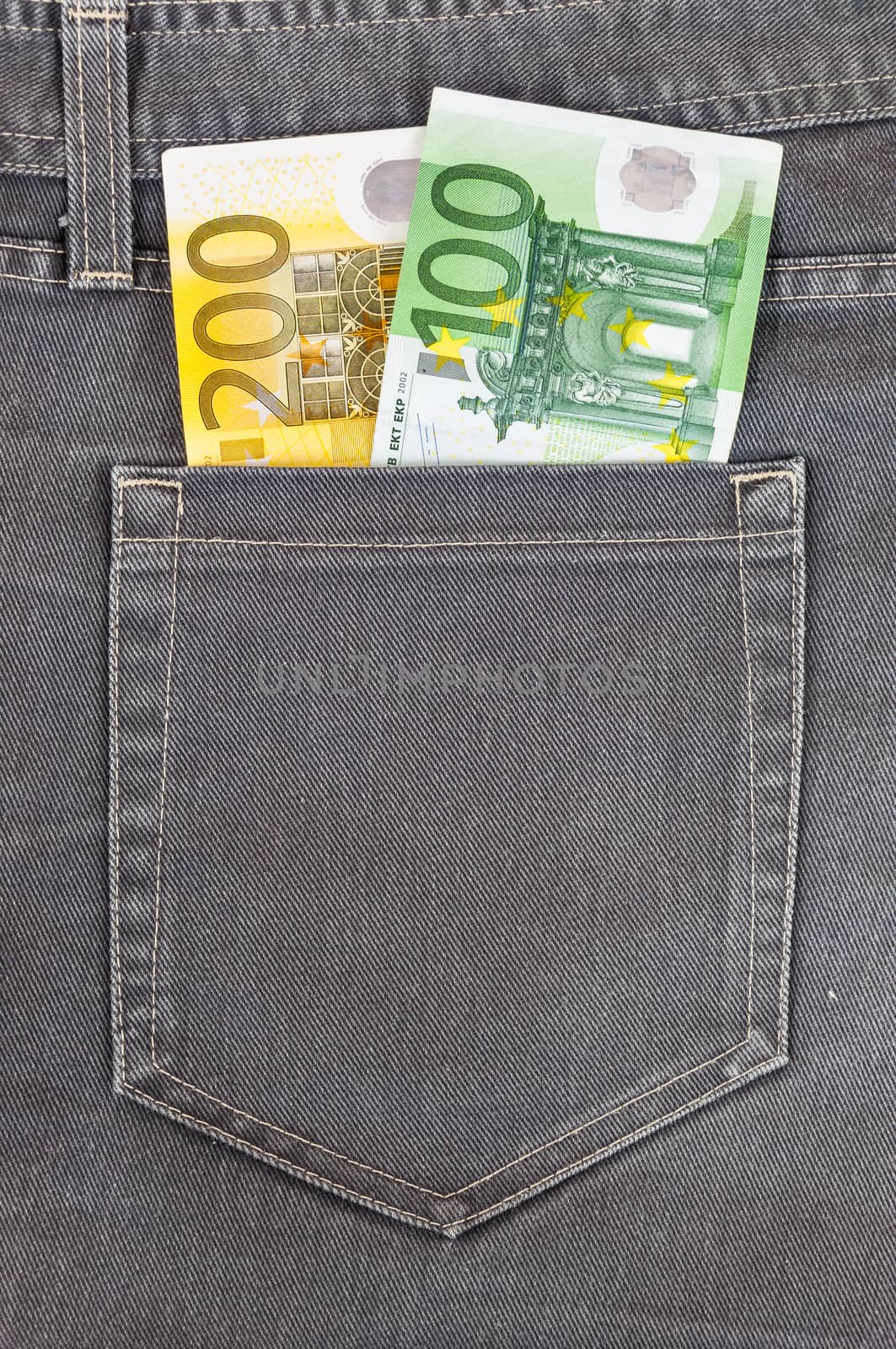 Euro banknotes in dark grey jeans pocket