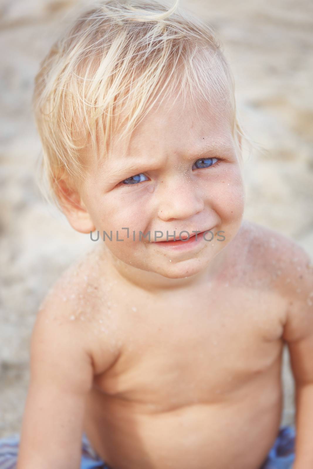 Portrait of a baby with a naked torso on the beach