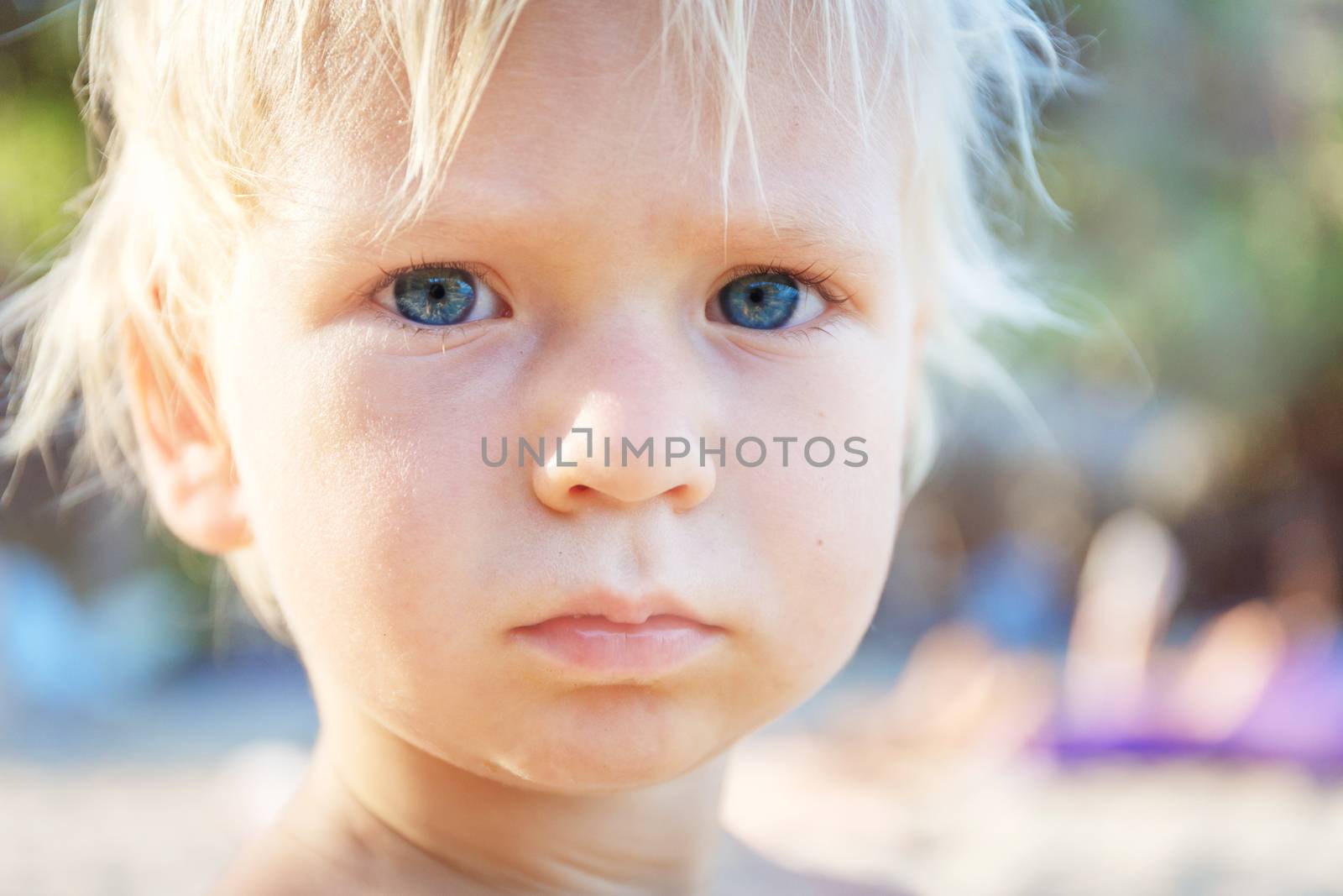 Baby with blond hair and blue eyes on the beach