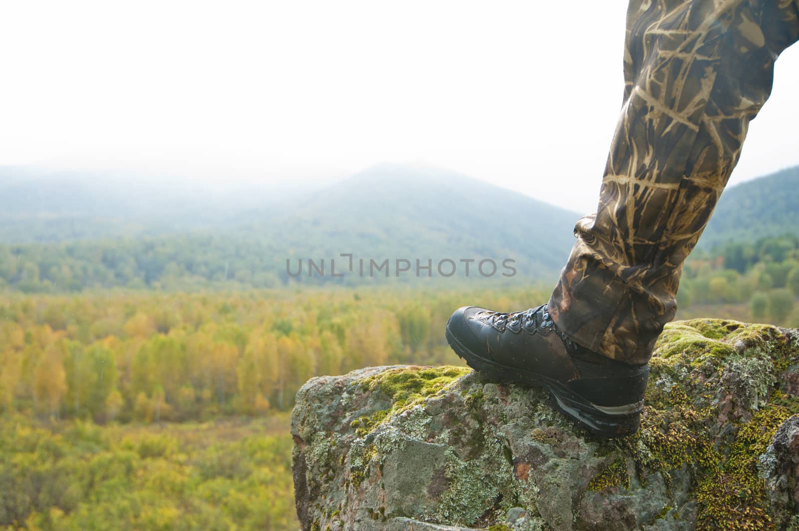 Tourist at sunrise in mountain taiga