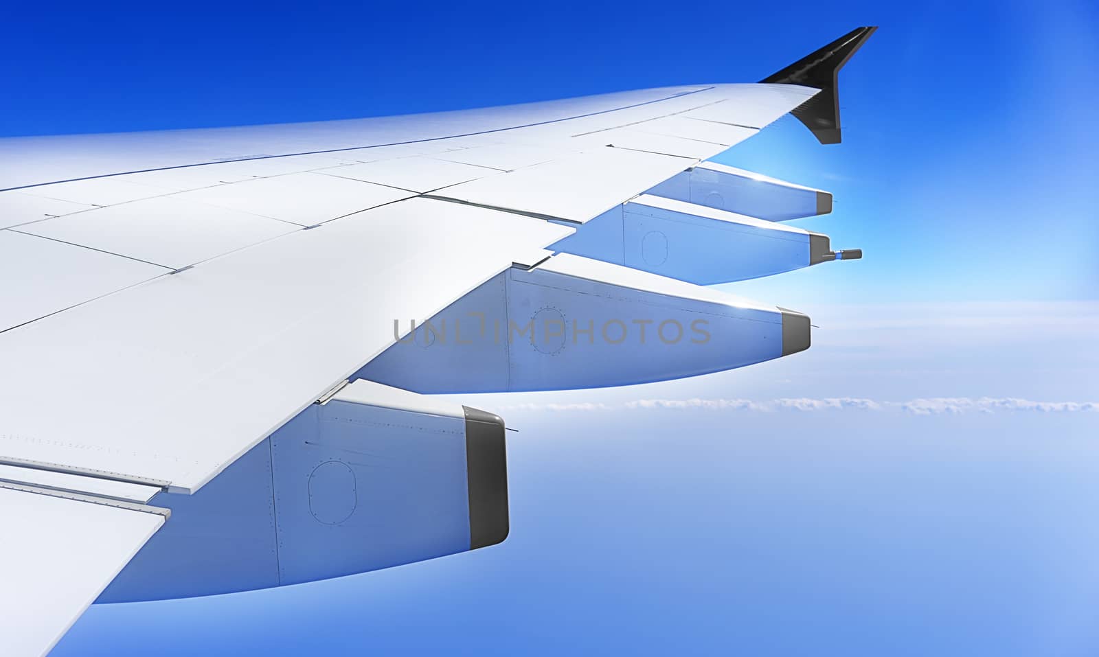 aeroplane wing, plane  travelling at high altitude with blue sky