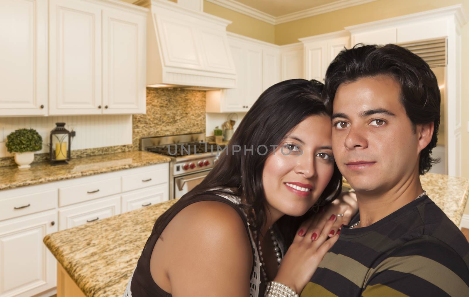 Affectionate Hispanic Couple Inside Custom Kitchen Interior.