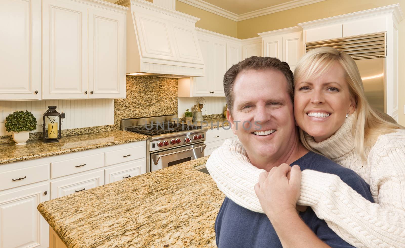 Happy Couple Hugging Inside Beautiful Custom Kitchen.