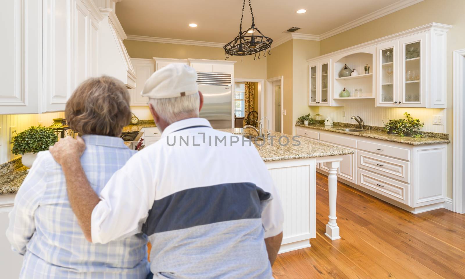 Senior Couple Looking Over Beautiful Custom Kitchen by Feverpitched