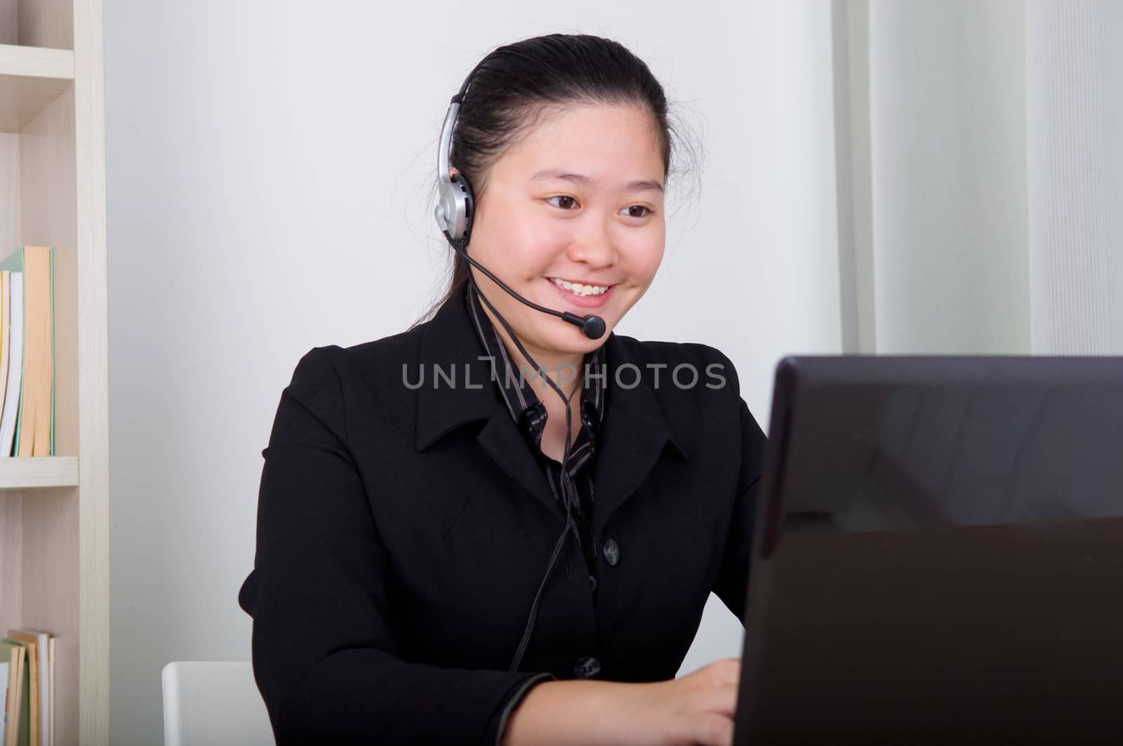 Beautiful asia young business woman with headset and laktop