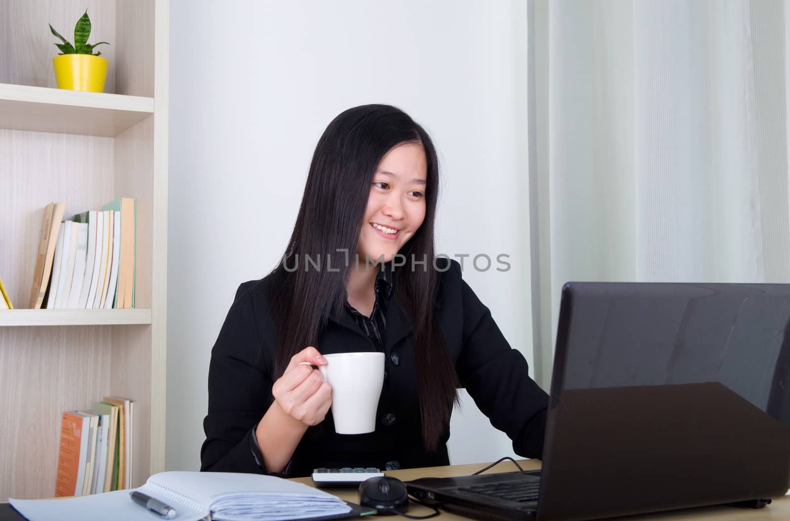 beautiful young business woman drinking coffee in office