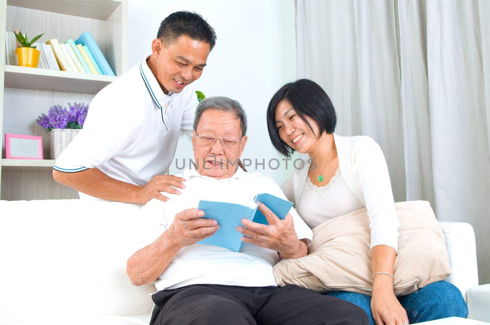 Asian family reading book at home