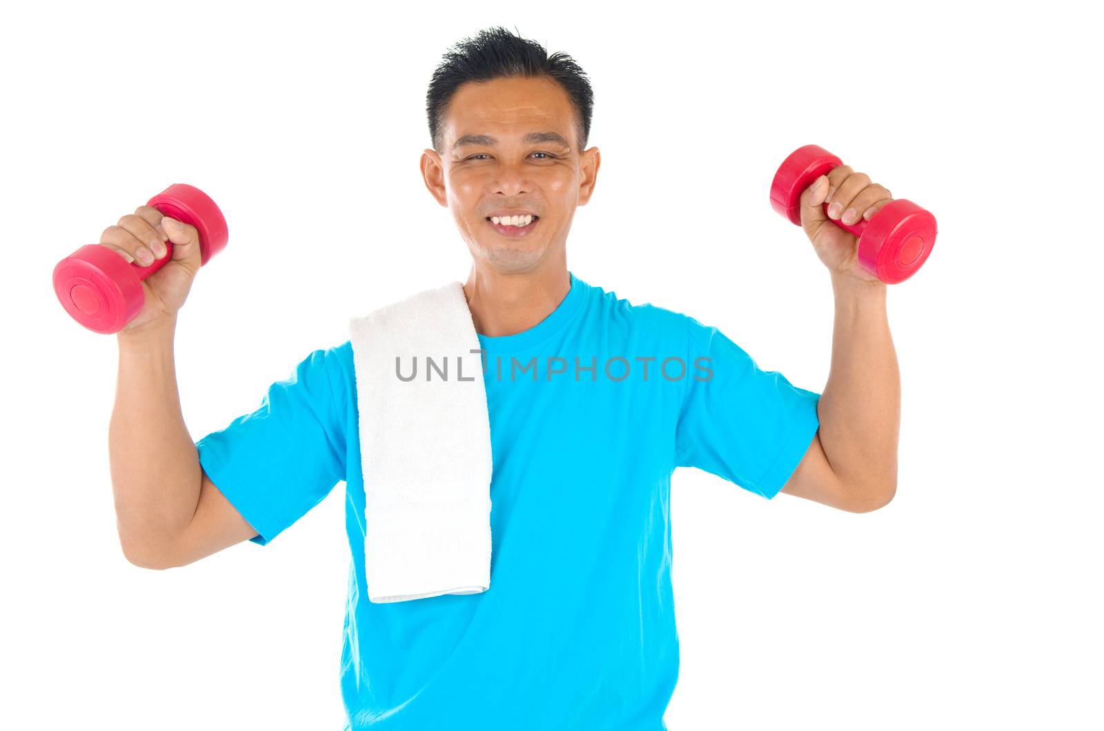 Portrait of fitness man working out with free weights in studio

