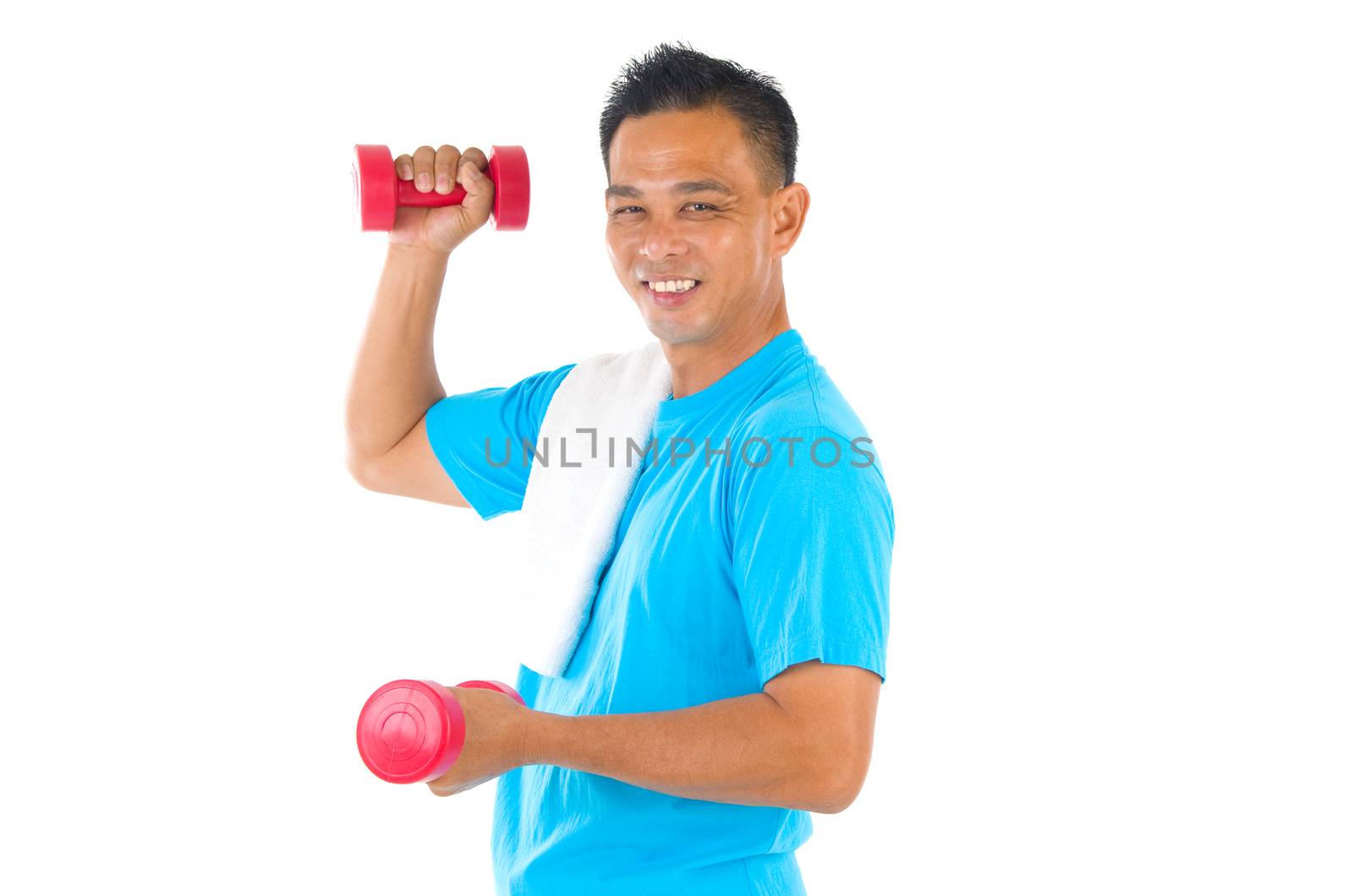 Portrait of fitness man working out with free weights in studio
