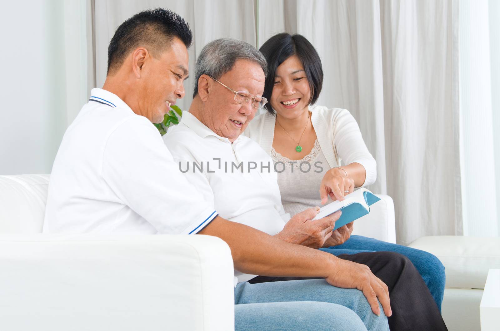 Asian family reading book at home