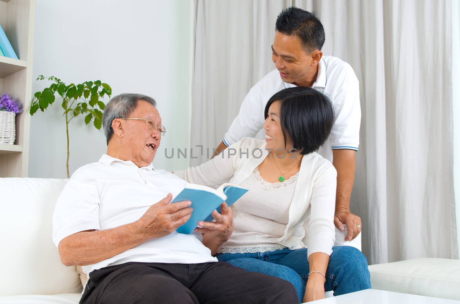 Asian family reading book at home