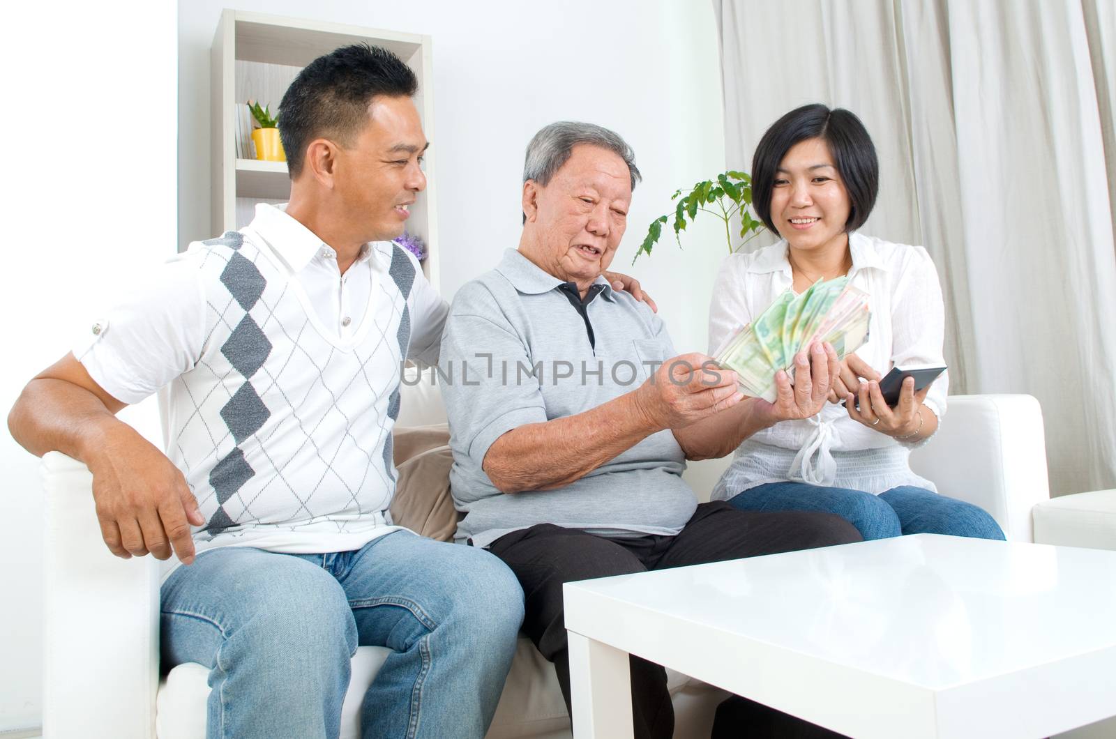 Asian senior man and children calculating money at their home