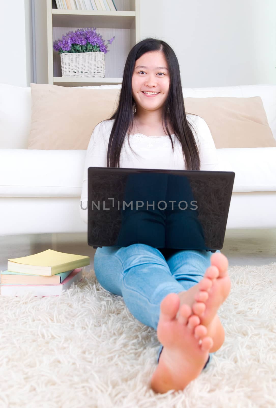 Portrait of attractive Asian girl using laptop. Young woman indoors living lifestyle at home.