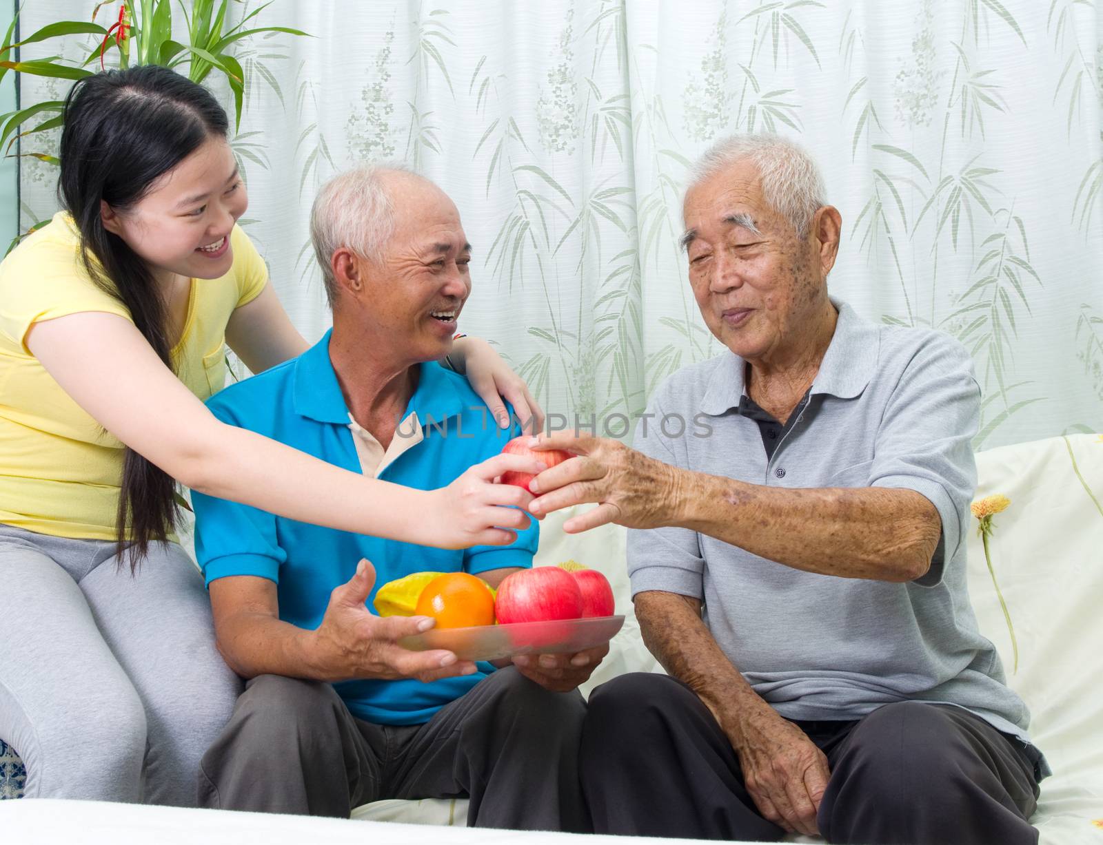 Happy asian family eating healthy fruit.