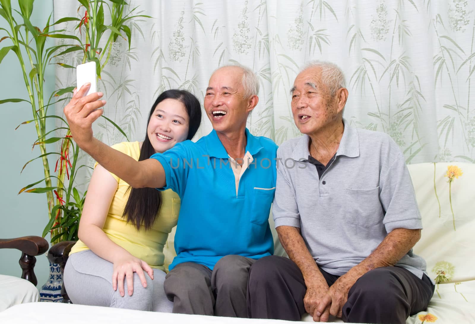 Modern technology, age and people concept. Asian family using smart-phone, self photographing. Family living lifestyle at home.