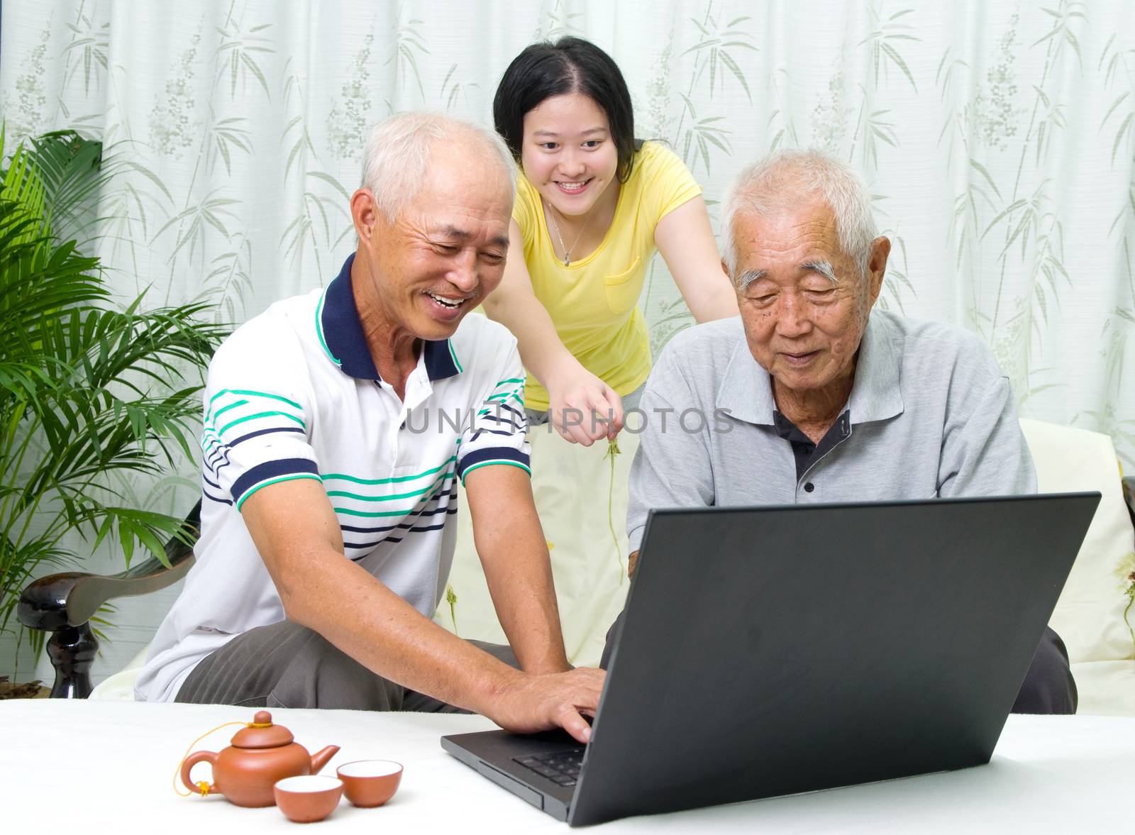 Asian senior man learns to use tablet computer