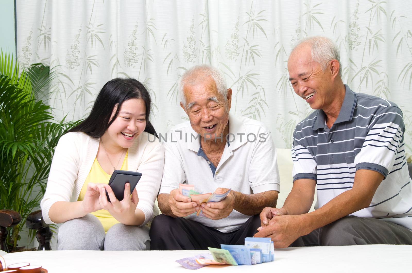 Asian senior man and children calculating money at their home