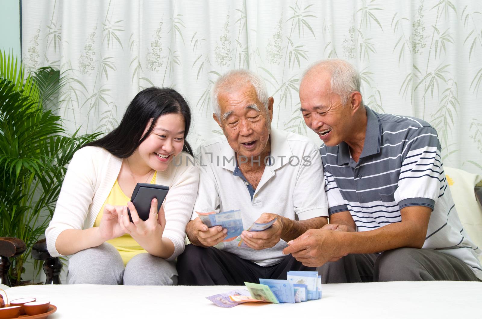 Asian senior man and children calculating money at their home