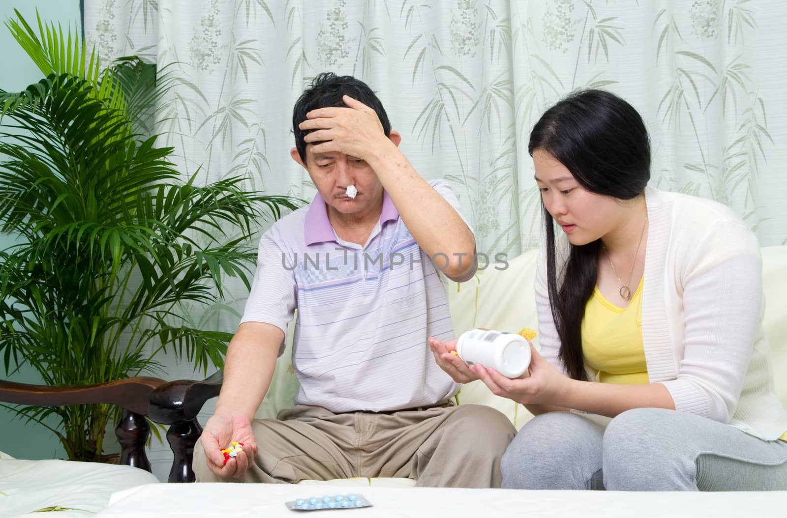 Asian man having medicine at home. Daughter take care of her father. 