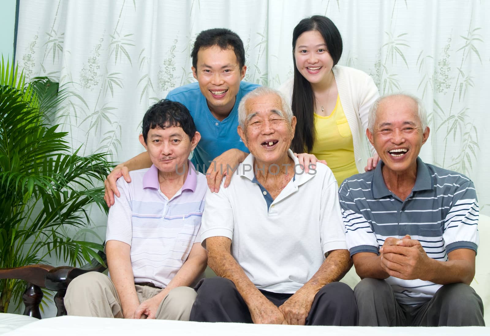 Asian senior father with his adult sons and granddaughter at home. Family living lifestyle.