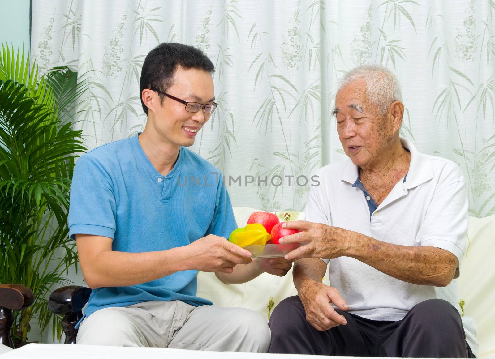 Happy asian family eating healthy fruit.