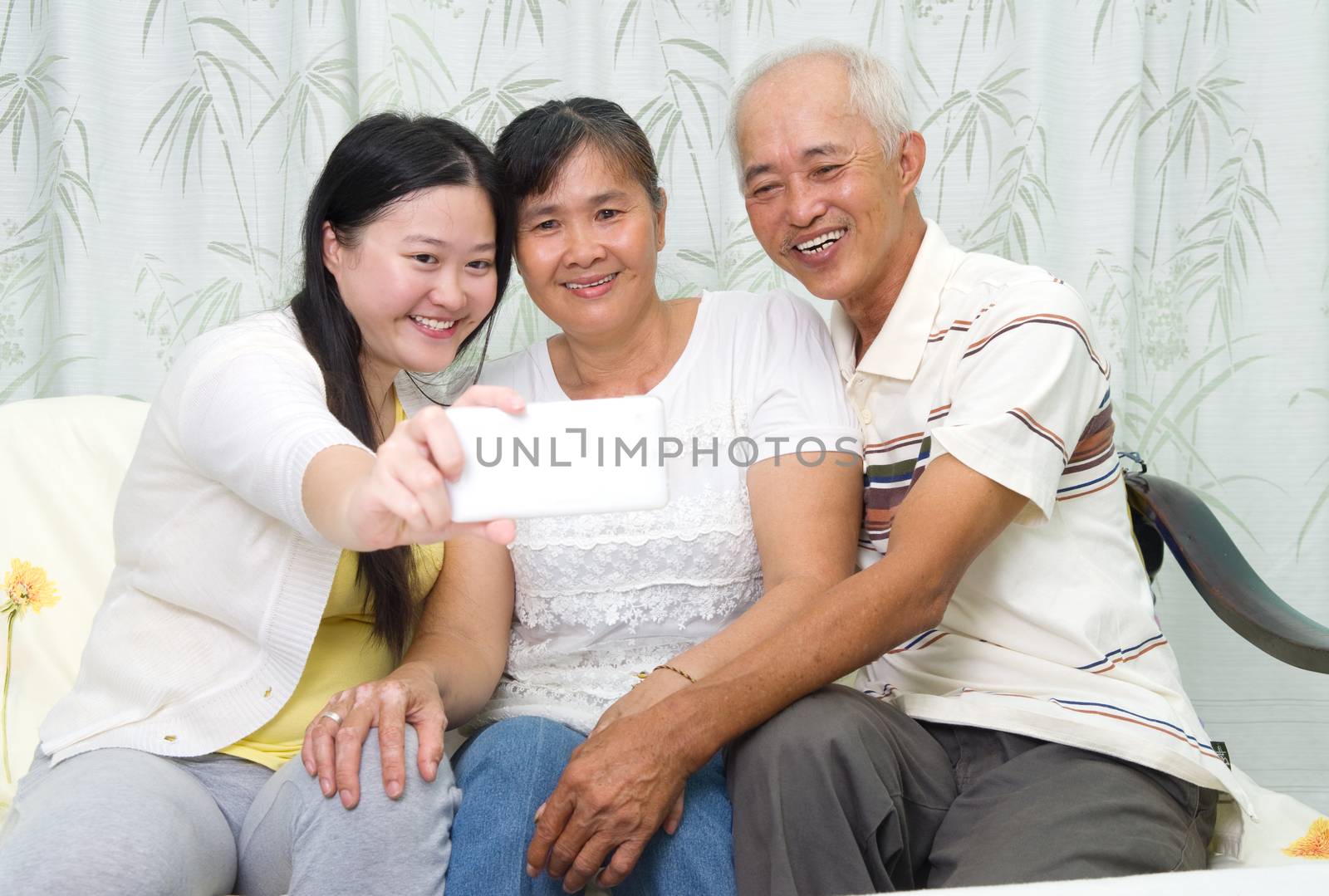 Modern technology, age and people concept. Asian girl with his parent taking selfie, using smartphone, self photographing.