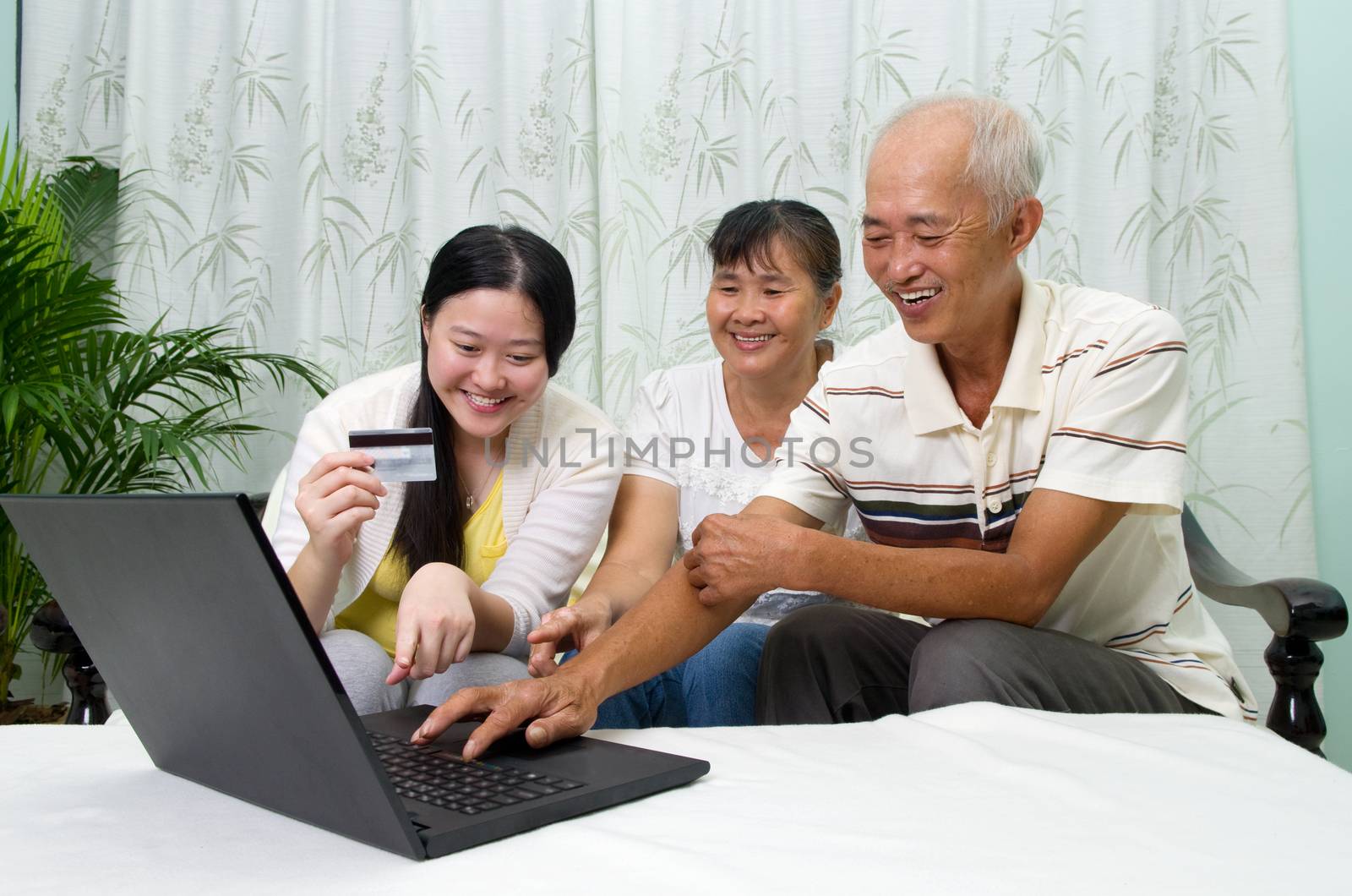 Asian parent learns to use online internet banking with their daughter