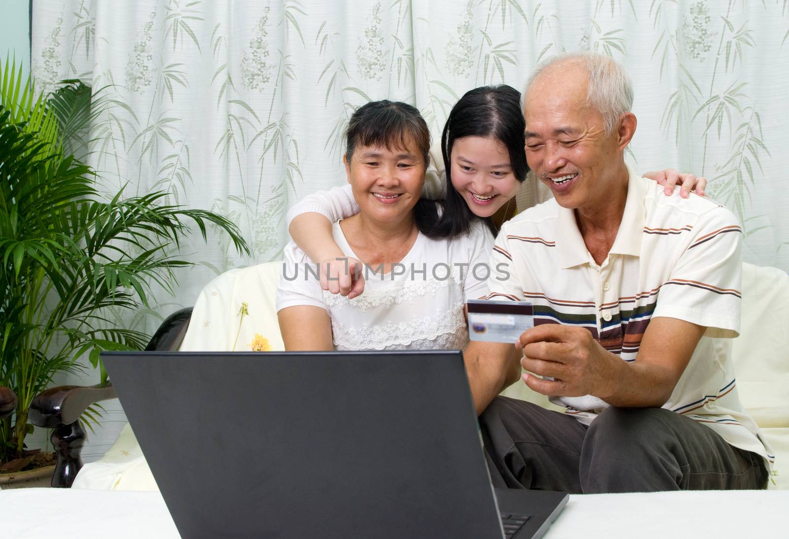 Asian parent learns to use online internet banking with their daughter