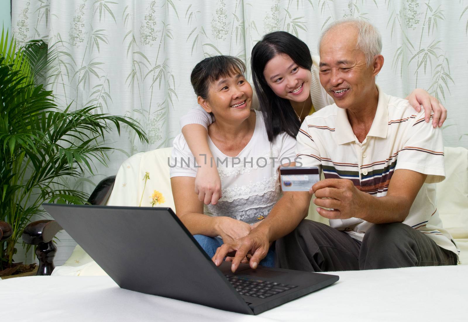 Asian parent learns to use online internet banking with their daughter