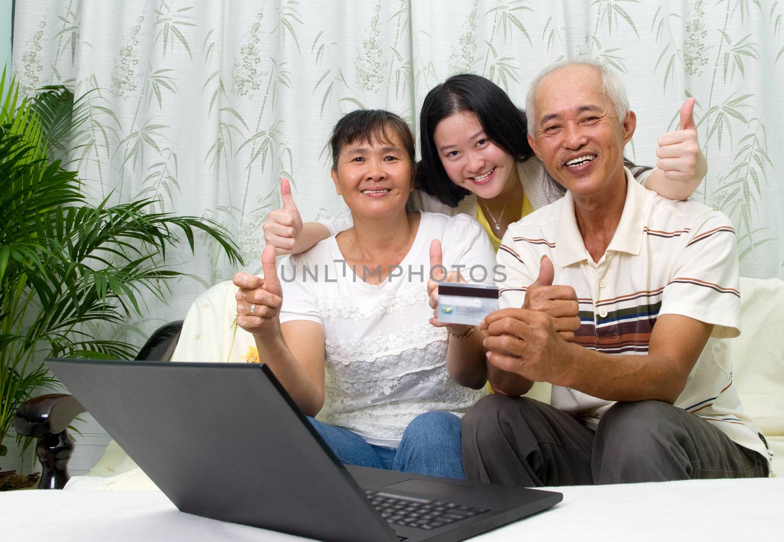 Asian parent learns to use online internet banking with their daughter