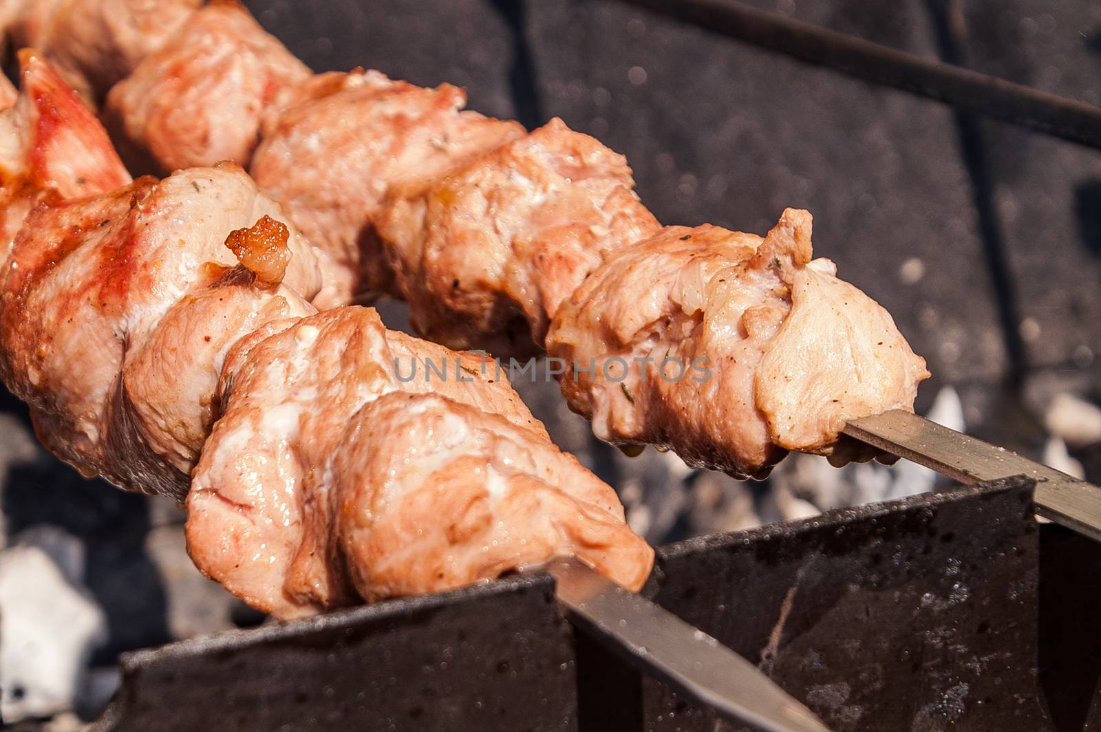 Shish kebab on a skewer fried on open coals of a fire